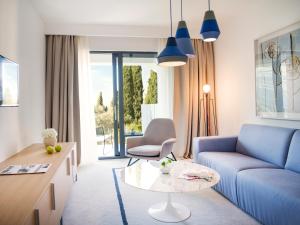 a living room with a blue couch and a table at Hotel Kompas in Dubrovnik