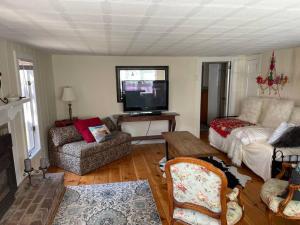 a living room with a couch and a flat screen tv at The Hideaway in Brewster