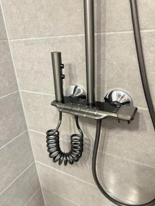 a phone hanging on a wall in a shower at Bright 1BR apartment in Kallio with best location in Helsinki +23 photos