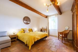 ein Schlafzimmer mit einem gelben Bett und einem Stuhl in der Unterkunft LE MAS DES FLANERAIES in Althen-des-Paluds + 124 Fotos
