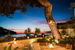 a restaurant with tables and chairs and a tree at Hotel Kompas in Dubrovnik