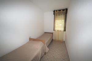 a small room with two beds and a window at Lovely 3 room flat in Rosolina with shared pool in Rosolina Mare +28 photos