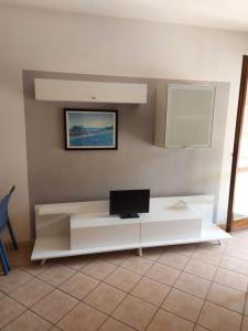 a living room with a white table with a laptop on it at Lovely 3 room flat in Rosolina with shared pool in Rosolina Mare