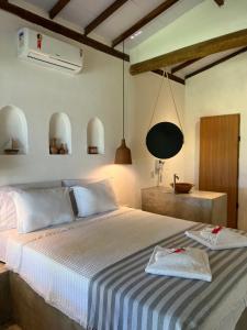 a bedroom with a bed with a blue and white blanket at Pousada Quintal Caraíva in Caraíva