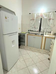 a kitchen with a white refrigerator and a sink at Departamento Batti in Asuncion