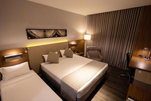 フォス・ド・イグアスにあるJL Hotel by Bourbonのホテルルーム ベッド2台&椅子付