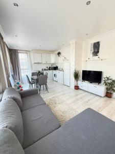 a living room with a gray couch and a kitchen at Vip Luxury APARTMENT in Burgas