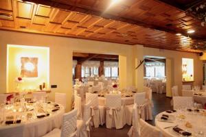 a banquet hall with white tables and white chairs at Hotel Nuovo Parco in Sestola