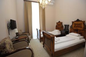 Habitación de hotel con 2 camas y lámpara de araña. en Bed & Breakfast Twenty, en Kikinda