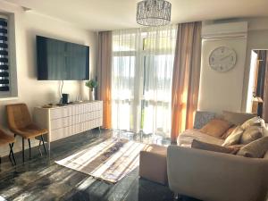 a living room with a couch and a tv at Violet Superior in Nyíregyháza