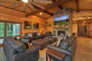 a living room with leather furniture and a fireplace at How Sweet It Is in Pittman Center