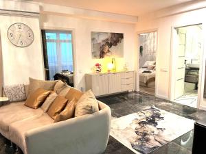 a living room with a couch and a clock on the wall at Violet Superior in Nyíregyháza