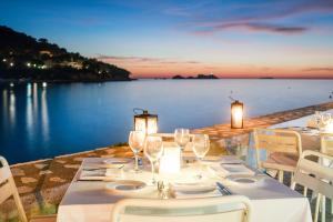 a table with wine glasses and a view of the water at Hotel Kompas in Dubrovnik