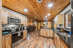 a kitchen with wooden cabinets and a living room at Twin Oak Creek in Gatlinburg