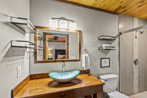 a bathroom with a blue bowl sink on a wooden counter at Twin Oak Creek in Gatlinburg +49 photos