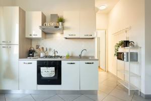 a kitchen with white cabinets and a stove top oven at Crystal House - Nido Verde in Florence