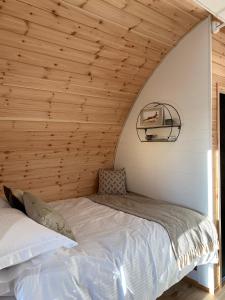 a bed in a room with a wooden ceiling at Hundle Dale- Bugthorpe Grange Glamping in Stamford Bridge