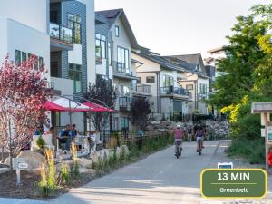 two people riding bikes down a street with buildings at Chill & Grill Firepit, Bbq, 70 Tv, Near Topgolf in Meridian