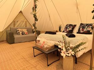 波特拉什North Coast Glamping - The Open 2025的一间卧室配有一张床,一张沙发位于帐篷内