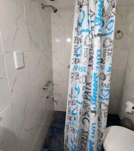 a bathroom with a shower curtain next to a toilet at Departamento en Miramar in Miramar