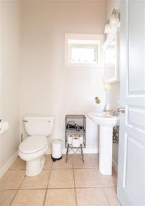 a white bathroom with a toilet and a sink at Bluebird Day - Pine Hideaway in Bend +50 photos
