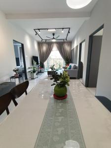 ein Wohnzimmer mit einem langen Tisch mit Stühlen und einem Sofa in der Unterkunft Dream 6 Emerald avenue in Cameron Highlands