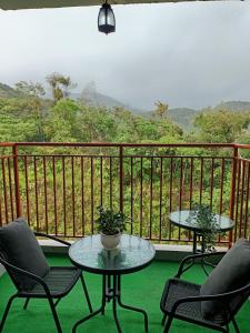 zwei Tische und Stühle auf einem Balkon mit Aussicht in der Unterkunft Dream 6 Emerald avenue in Cameron Highlands
