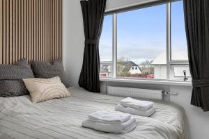 a bedroom with a bed with two towels on it at Lovely & Spacious Apartments in Reykjavík