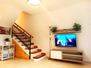 a living room with a television and a staircase at Maravilloso Bungalow in Gran Alacant
