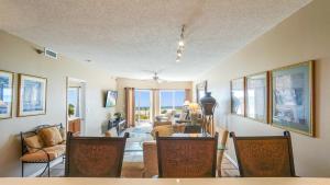 a living room with a table and chairs in a room at Emerald Isle Gulf Front 2B Condo - 104 in Pensacola Beach