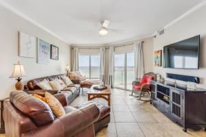 sala de estar con sofás de cuero y TV de pantalla plana en Emerald Isle Gulf Front 2B Condo - 707, en Pensacola Beach