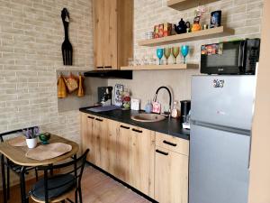 a kitchen with a white refrigerator and a table at Apartman "CHARLIZE" with PRIVATЕ PARKING in Novi Sad