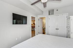 a white bedroom with a bed and a ceiling fan at Emerald Isle Gulf Front 2B Condo - 1604 in Pensacola Beach +21 photos
