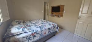 una piccola camera da letto con un letto con copriletto floreale di Casa Celeste a Boa Vista