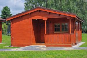 a small wooden cabin in the grass at Domki caloroczne Hotel Zagiel in Niewiesze