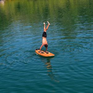 a person standing on a paddle board in the water at Aventura náutica em Paraty hospedagem flutuante na cidade Veleiro Maverick in Paraty