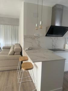eine Küche mit Arbeitsplatte und zwei Hockern in der Unterkunft Ca Maruja in Cullera