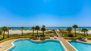 a pool with the beach in the background at Emerald Isle Gulf Front 3B Condo - 1208 in Pensacola Beach