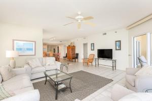 a living room with white furniture and a flat screen tv at Emerald Isle Gulf Front 3B Condo - 1208 in Pensacola Beach