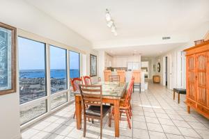 a dining room with a table and chairs and windows at Emerald Isle Gulf Front 3B Condo - 1208 in Pensacola Beach
