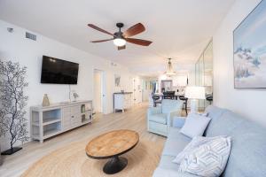 a living room with a blue couch and a table at Emerald Isle Gulf Front 2B Condo - 805 in Pensacola Beach
