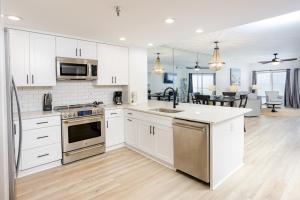 a kitchen with white cabinets and a dining room at Emerald Isle Gulf Front 2B Condo - 805 in Pensacola Beach