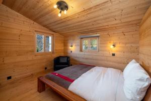 a bedroom with a bed in a wooden cabin at Chalet Les Aragnes Family chalet La Tzoumaz in Riddes