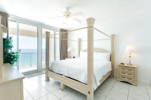 a bedroom with a canopy bed with a view of the ocean at Regency Towers Gulf Front 3B Condo in Navarre