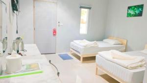 Postel nebo postele na pokoji v ubytování บ้านไม้หอมบูติค สวนผึ้ง