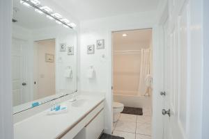 a white bathroom with a sink and a toilet at Regency Towers Gulf Front 3B Condo in Navarre +37 photos