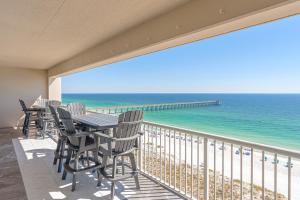 a balcony with a table and chairs and the ocean at Regency Towers Gulf Front 3B Condo in Navarre