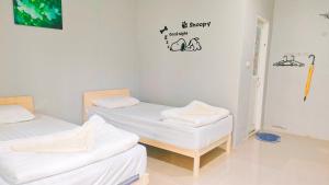 Postel nebo postele na pokoji v ubytování บ้านไม้หอมบูติค สวนผึ้ง
