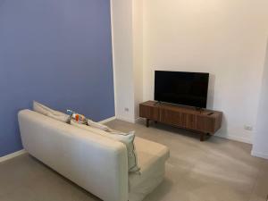 un soggiorno con divano e TV a schermo piatto di Apartment in Affori a Milano