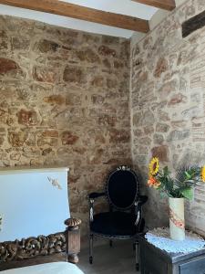 a room with a chair and a stone wall at Apartamento La Glorieta, Centro Denia in Denia